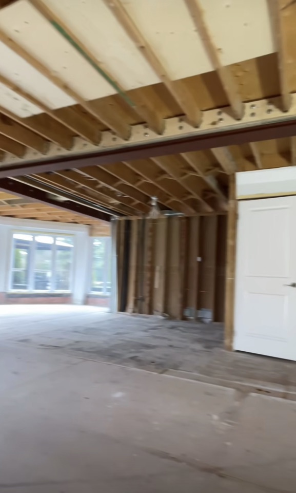 Framed room with exposed ceiling joists, wall studs and a window